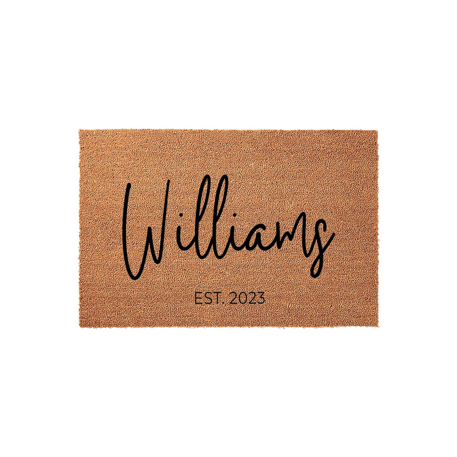 Personalized family name coir doormat featuring a natural tan fiber texture with black script lettering and an established date, providing a welcoming and durable entrance decor piece for any front porch or home entryway.