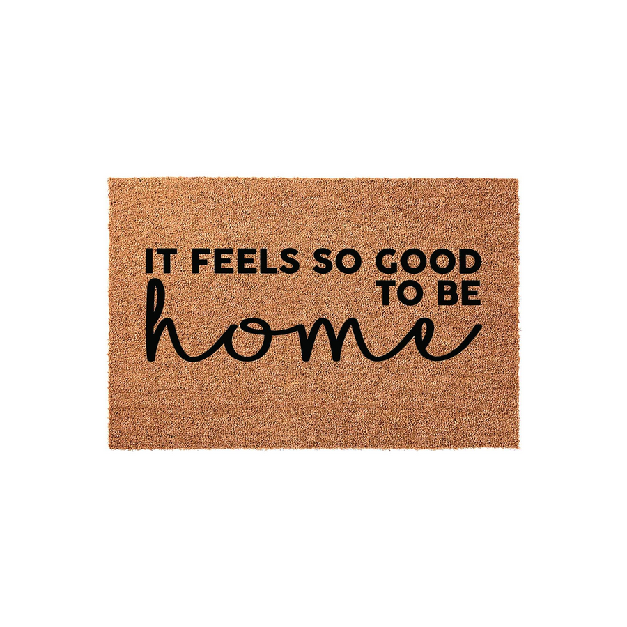It Feels So Good To Be Home coir doormat featuring a natural brown fiber texture and bold black typography, creating a welcoming entrance piece for your front porch or entryway that adds a cozy touch to any house decor.
