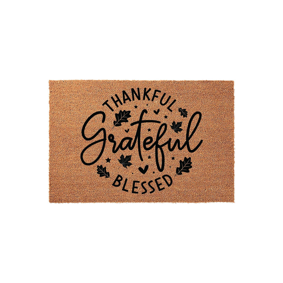 Thankful Grateful Blessed coir doormat featuring a natural tan fiber texture with black printed text and autumn leaf accents, creating a festive fall entryway decor piece for your front porch or home entrance during the harvest