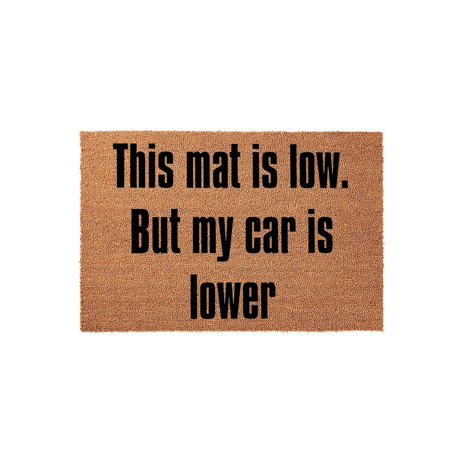 Funny Car Enthusiast Doormat featuring a natural coir texture and bold black text that reads This mat is low. But my car is lower, making it a humorous welcome mat for any garage or home entrance with a car lover's unique style.