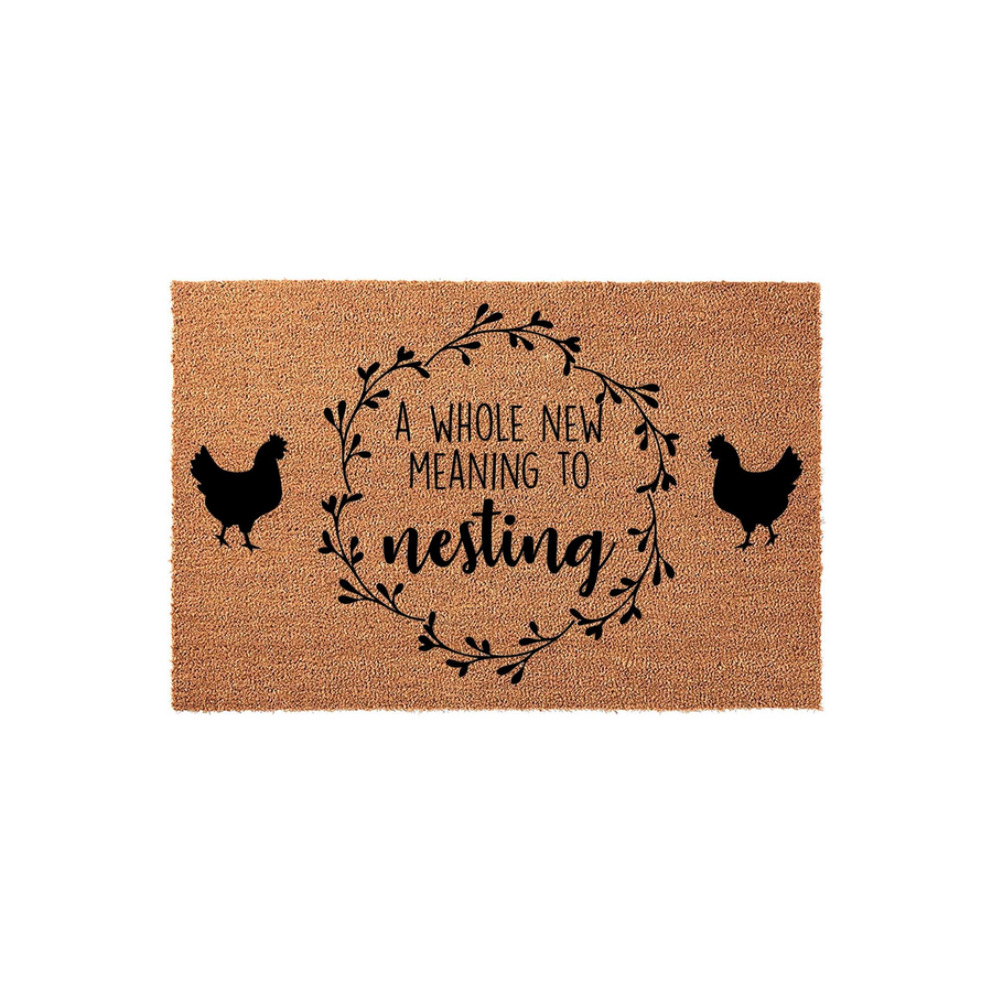Farmhouse Chicken Nesting Doormat featuring a natural coir texture with a black printed wreath design, two chicken silhouettes, and the text A Whole New Meaning To Nesting centered on a plain white background.