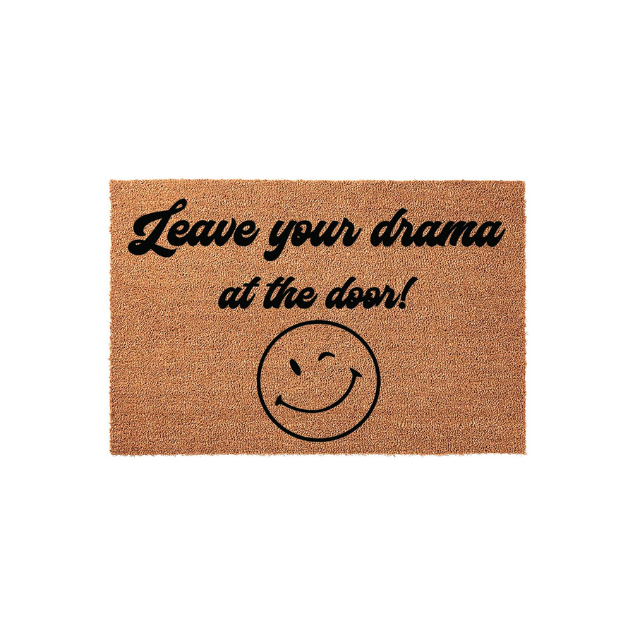 Leave Your Drama At The Door doormat made of natural coir fibers, featuring bold black text and a winking smiley face icon centered on the mat, presented against a clean white background for a modern and humorous home entryway