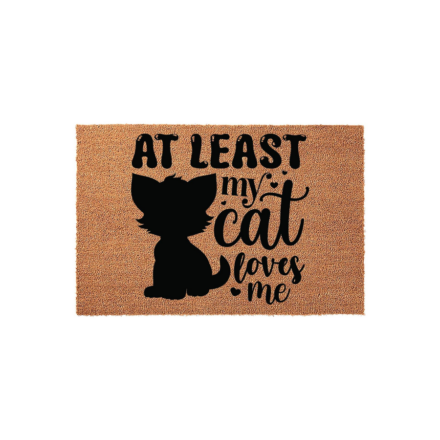 At Least My Cat Loves Me coir doormat featuring a black silhouette of a fluffy kitten and playful typography on a natural tan fiber background, making a humorous entryway decor piece for any cat lover's home front porch or indoor