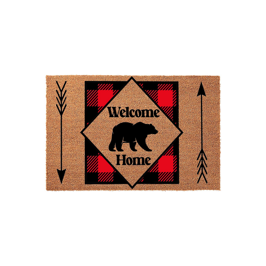 Rustic Bear Welcome Home Doormat featuring a black bear silhouette centered on a red and black buffalo plaid diamond pattern, accented by decorative arrows on a natural coir fiber background for a cozy cabin entryway decor style.
