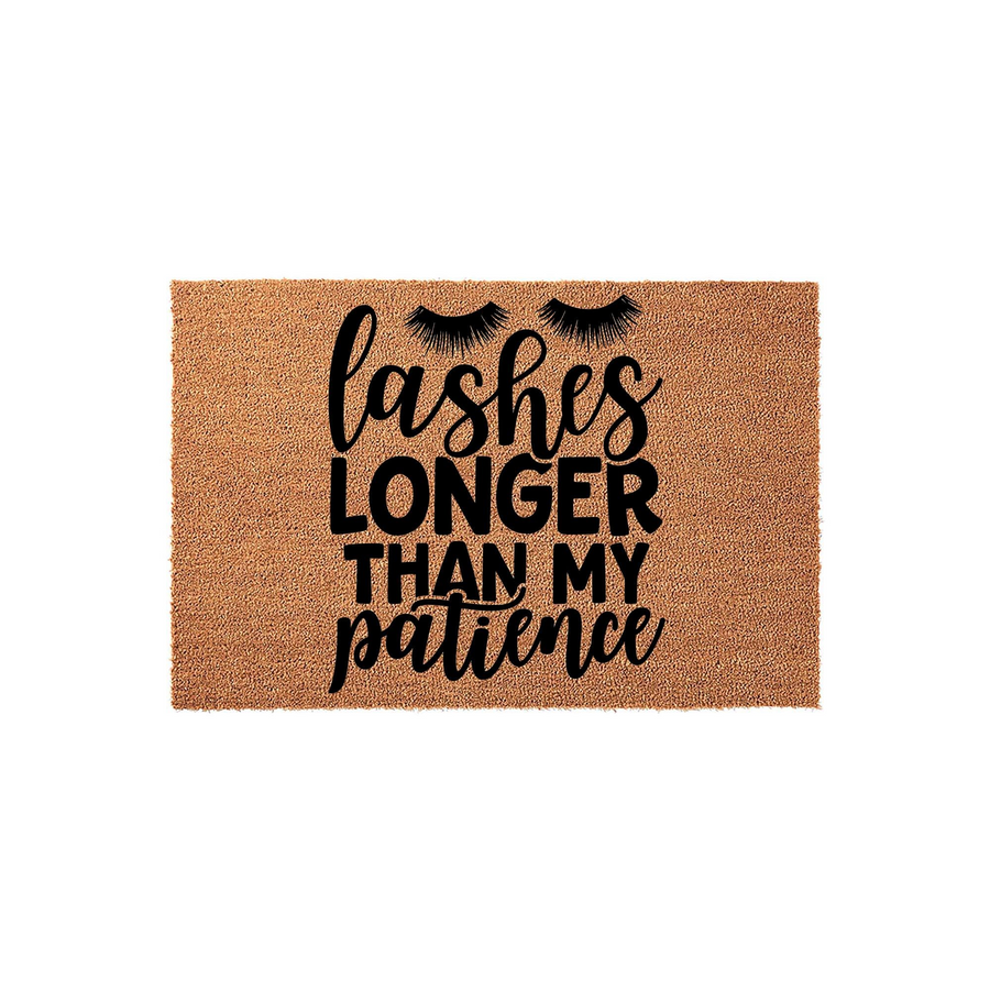 Funny Lashes Longer Than My Patience coir doormat featuring bold black typography and stylized eyelash graphics on a natural brown coconut fiber background, perfect for a humorous entryway or front porch decor statement piece.