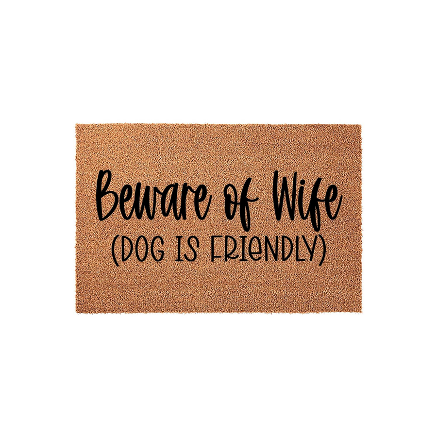 Beware of Wife Dog is Friendly coir doormat featuring a natural tan fiber texture and bold black lettering, providing a humorous welcome for guests while highlighting the friendly nature of the family pet at the front door