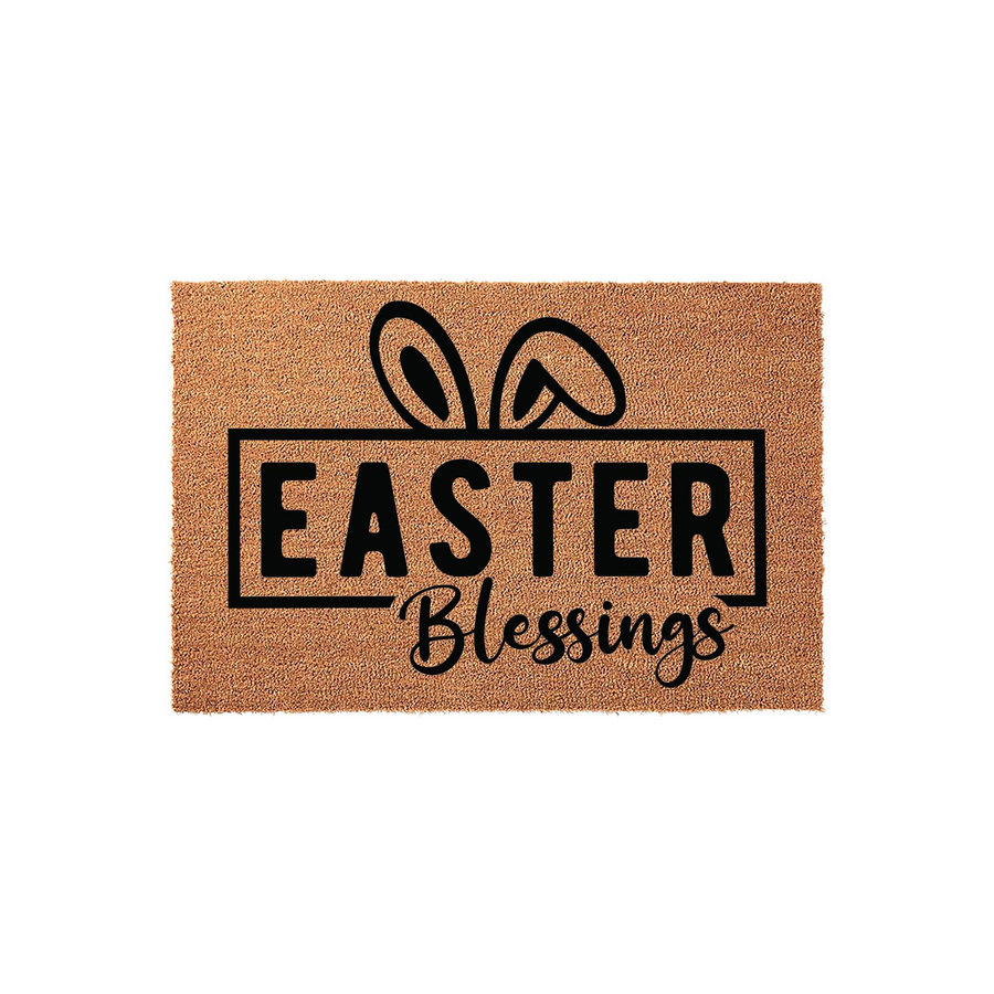 Easter Blessings coir doormat featuring a natural tan fiber texture with black printed text and cute bunny ears peeking out from behind a rectangular frame, creating a festive spring entryway decor piece for your front porch.