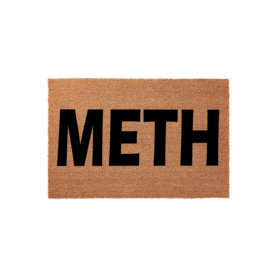 Funny novelty coir doormat featuring the word METH printed in bold black capital letters against a natural brown textured fiber background, creating a humorous and eye-catching entrance rug for a home or apartment front door