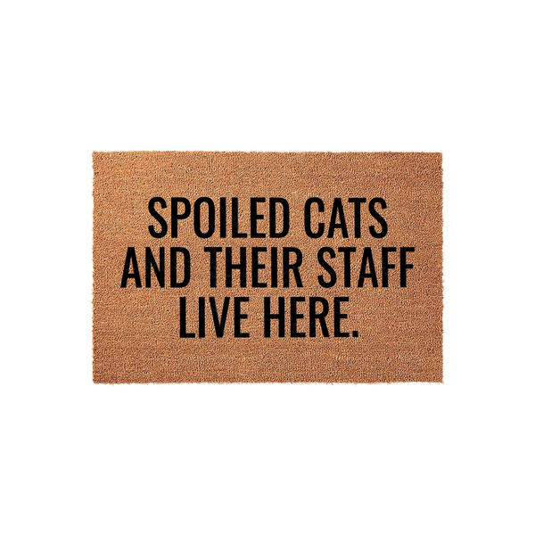 Spoiled Cats and Their Staff Live Here coir doormat featuring bold black text on a natural brown fiber background, making it a funny and welcoming entrance rug for any cat lover's home front porch or entryway decor.