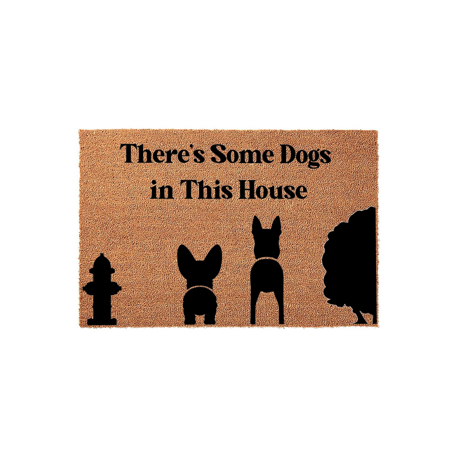 There's Some Dogs in This House coir doormat featuring black silhouettes of a fire hydrant, a Corgi, a German Shepherd, and a large bush against a natural tan textured background, creating a fun and welcoming entryway for pet