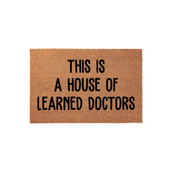 This is a House of Learned Doctors doormat featuring bold black lettering printed on a natural tan coir fiber mat, providing a humorous and professional welcome for the front porch of any medical professional or doctor's home.