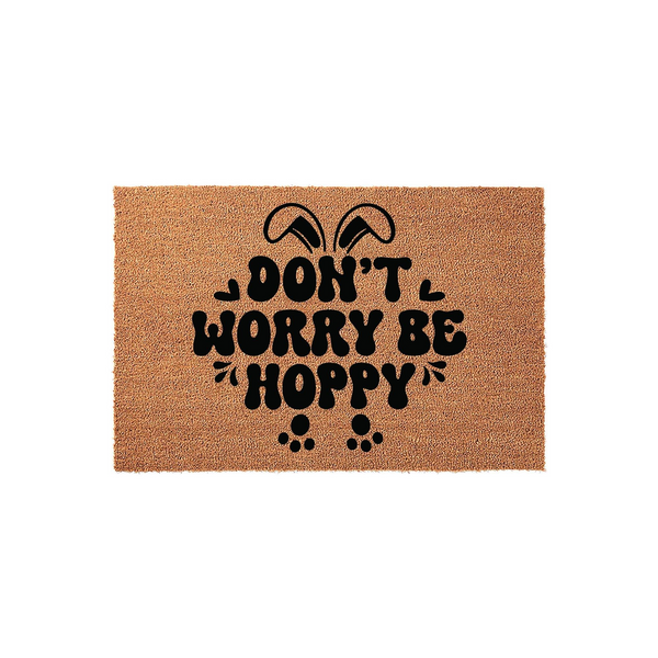 Easter Bunny Doormat featuring a natural coir texture with black text that reads Don't Worry Be Hoppy, accented by cute rabbit ears and paw prints for a festive spring home decor look on a plain white studio background.