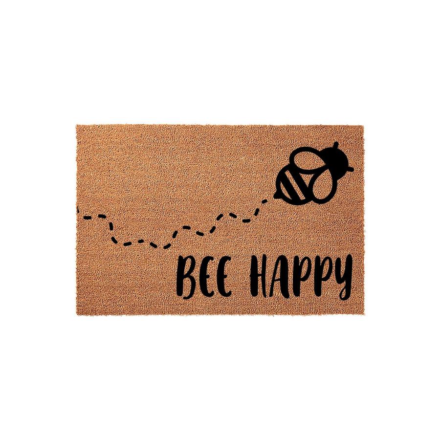 Bee Happy coir doormat featuring a cute black bumblebee illustration with a dashed flight path trail across the natural brown fiber surface, creating a cheerful and welcoming entrance decor piece for your front porch or home