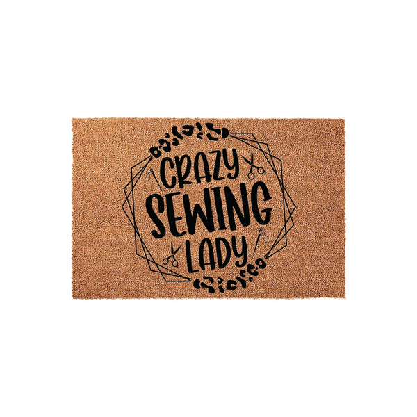 Crazy Sewing Lady coir doormat featuring a black printed design with geometric lines, scissors, and needle icons, set against a natural tan fiber background for a fun and functional entryway decor piece for any craft room or home.