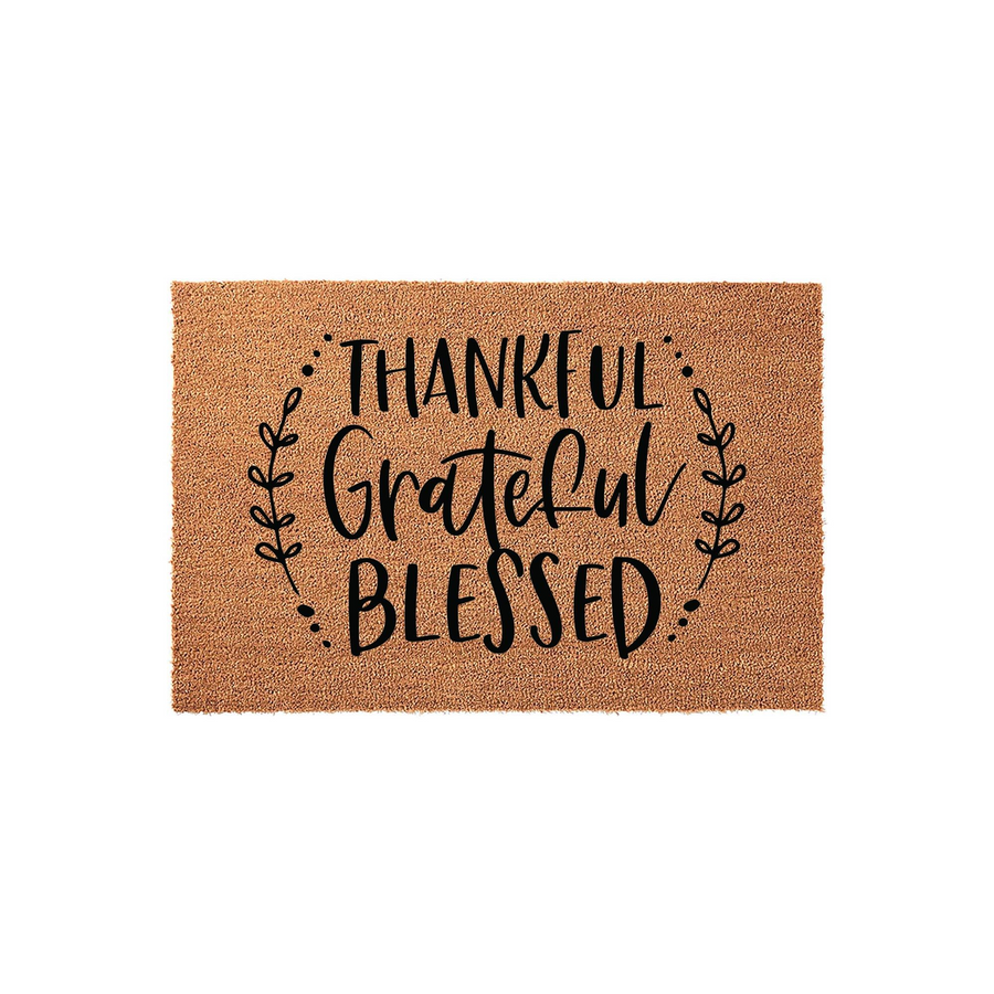 Thankful Grateful Blessed coir doormat featuring a natural tan fiber texture and black script lettering framed by delicate leafy branches, creating a welcoming farmhouse style entrance decor piece for your front porch or home