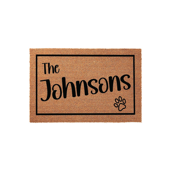 Personalized family name coir doormat featuring a black rectangular border, the text The followed by a custom last name, and a small paw print icon in the corner, set against a clean white background for a modern home entryway