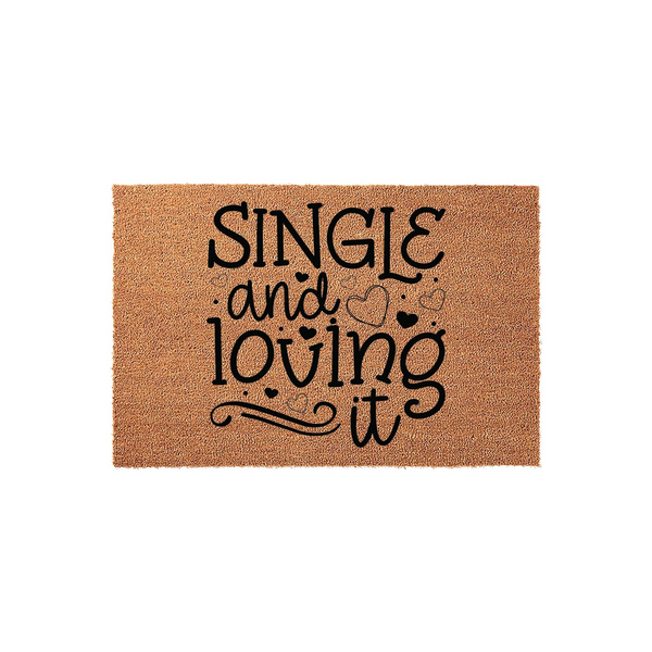 Single and Loving It Coir Doormat featuring bold black typography on a natural tan textured surface, accented with decorative heart outlines and swirls to create a fun, welcoming entrance piece for a modern home or apartment
