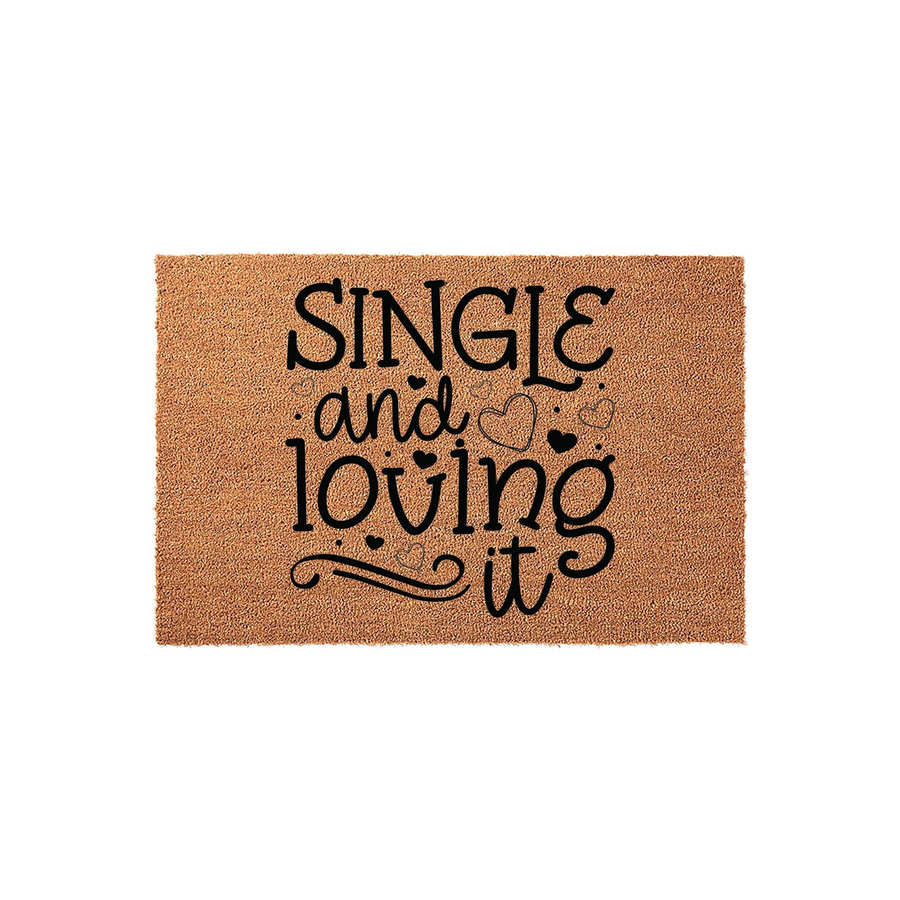 Single and Loving It Coir Doormat featuring bold black typography on a natural tan textured surface, accented with decorative heart outlines and swirls to create a fun, welcoming entrance piece for a modern home or apartment