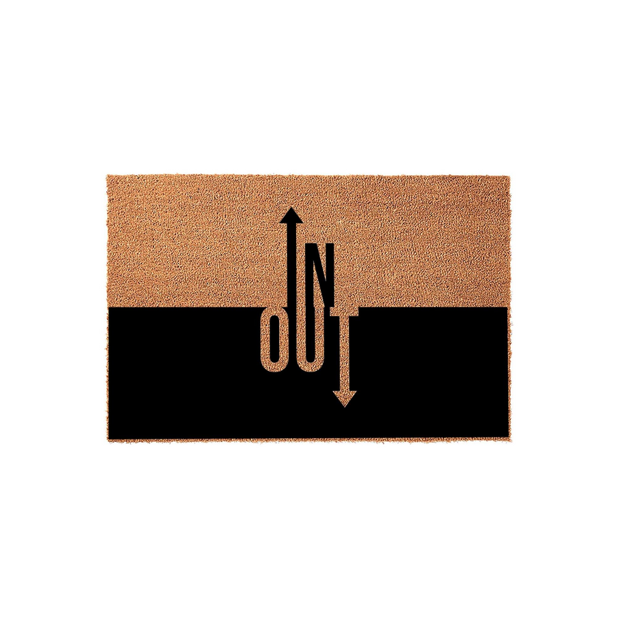 In and Out funny doormat featuring a natural coir top half and a solid black bottom half, with the words IN and OUT printed in a clever vertical design that uses arrows to point in opposite directions against a plain white