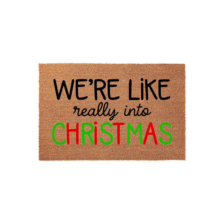 Christmas doormat featuring a natural coir texture with the text We are like really into Christmas printed in a mix of black, red, and green fonts, creating a festive holiday welcome for your front porch or entryway decor.