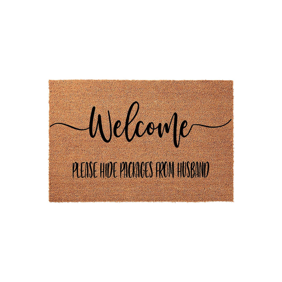 Funny Welcome Doormat with the text Please Hide Packages From Husband printed in black ink on a natural tan coir fiber mat, featuring a modern script font for a humorous and functional front porch decor piece for your home