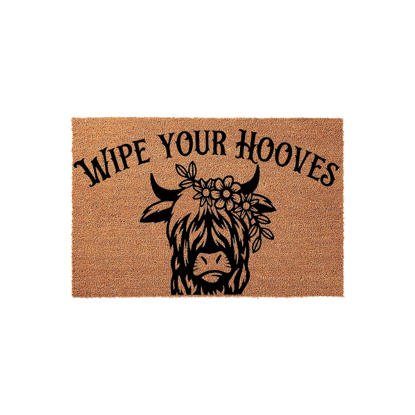 Highland Cow Wipe Your Hooves doormat featuring a natural coir texture with a black printed illustration of a shaggy Highland cow wearing a floral crown, centered on a plain white background for a rustic farmhouse entryway decor