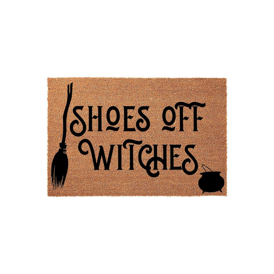 Shoes Off Witches Halloween doormat featuring a natural coir texture with black printed text, a broomstick icon on the left, and a small cauldron graphic on the right for a fun, spooky entryway decor piece for the fall season.