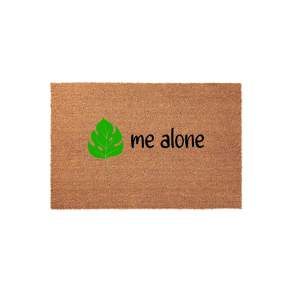 Leave me alone coir doormat featuring a vibrant green monstera leaf illustration on a natural brown fiber background, providing a humorous and welcoming touch to your front porch entryway decor with its bold black text design.