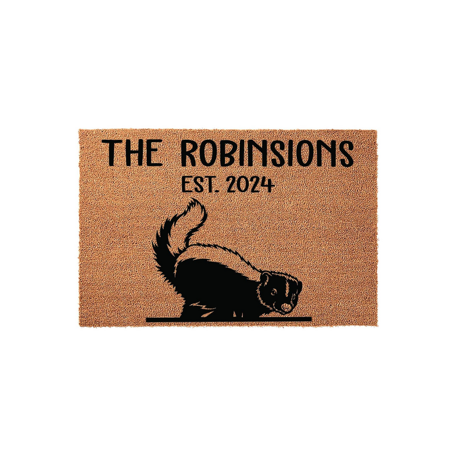 Personalized skunk family doormat featuring a cute black and white skunk illustration, custom family name text, and established year printed on a durable natural coir fiber mat against a clean white studio background.