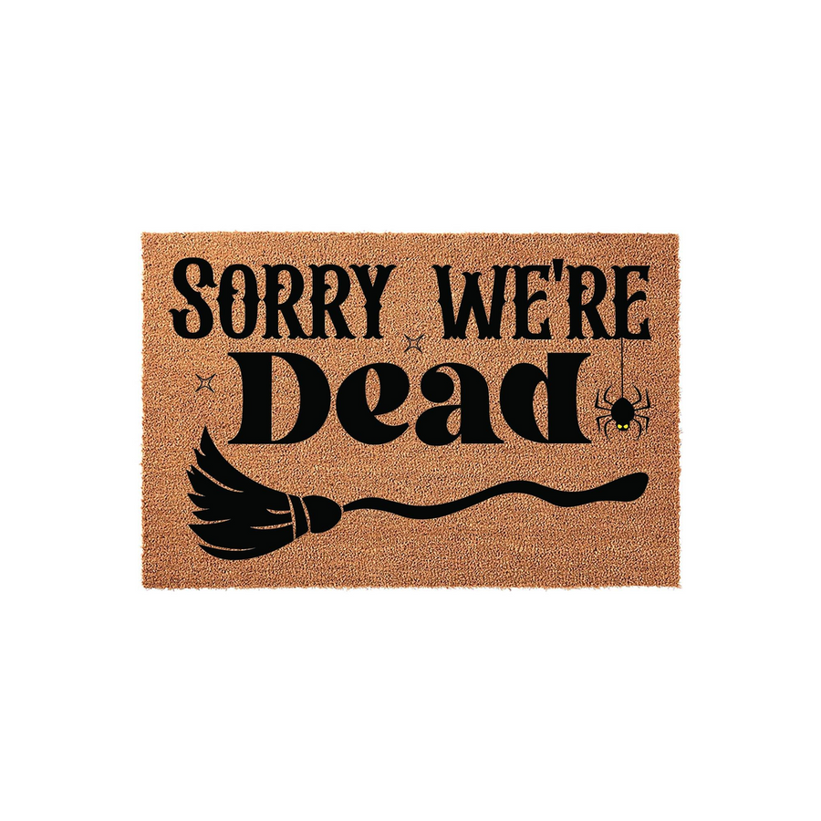 Sorry We're Dead Halloween doormat made of natural coir fiber, featuring black text, a witch's broomstick graphic, and a small spider hanging from a web on a plain white background for a spooky seasonal entryway decor accent.