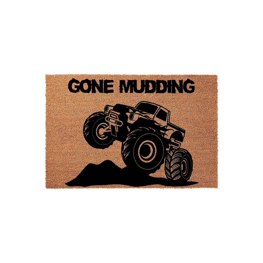 Gone Mudding monster truck doormat featuring a rugged black graphic of a large off-road vehicle jumping over a dirt mound, printed on a natural tan coir fiber mat that adds a fun, adventurous touch to any front porch or entryway