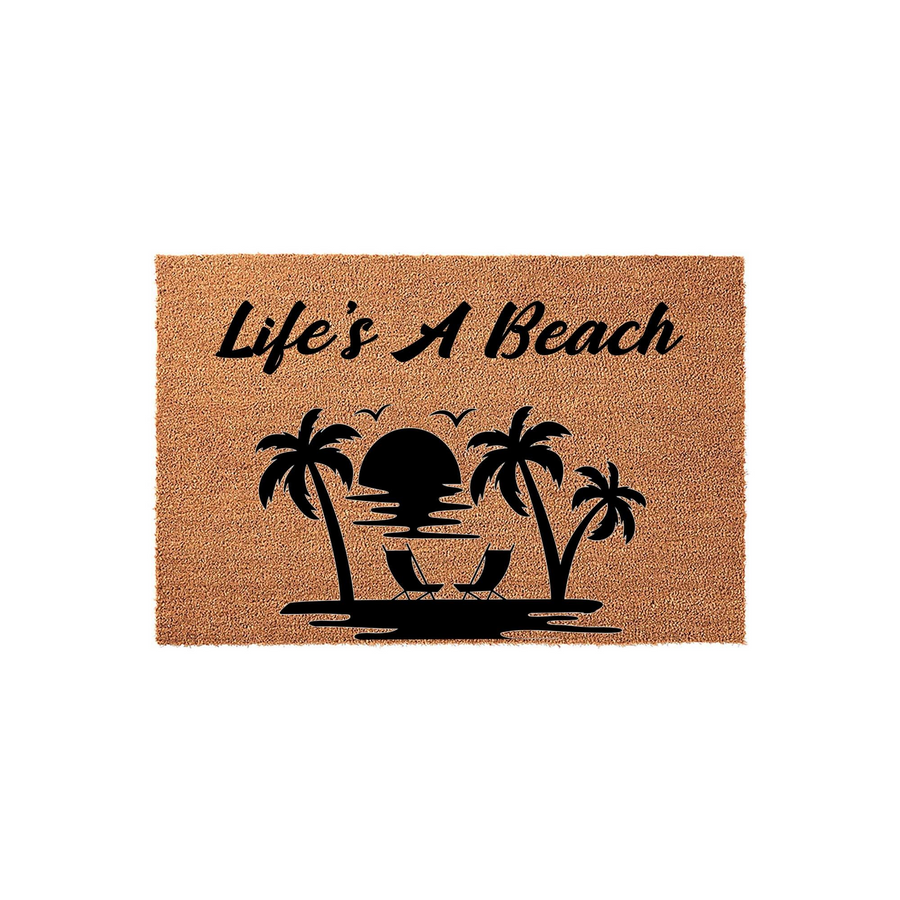 Life's A Beach coir doormat featuring a black silhouette design of palm trees, a sunset, and lounge chairs on a natural tan fiber background, creating a tropical coastal aesthetic for your front porch or entryway decor.