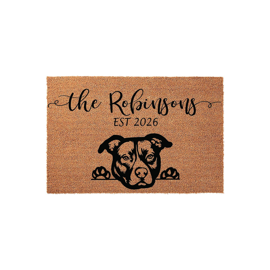 Personalized Pit Bull doormat featuring a cute dog peeking over the bottom edge, customized with a family name and established year on a natural coir fiber background, creating a welcoming entrance for any dog-loving home.