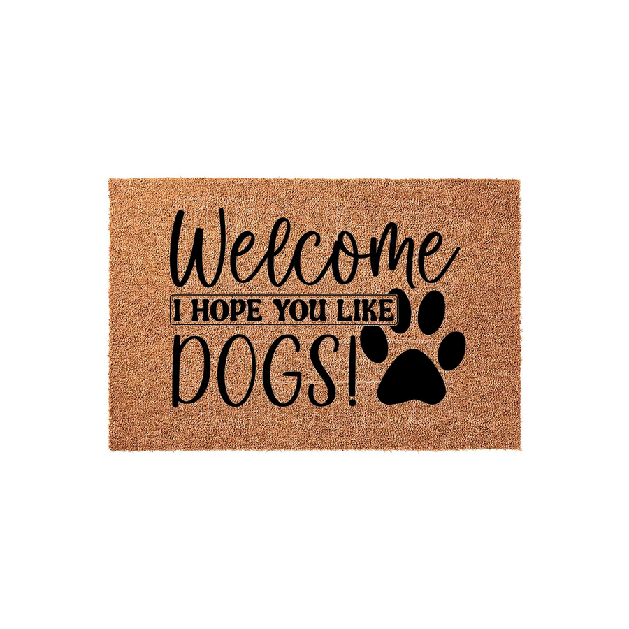 Dog lover welcome doormat made of natural coir fiber featuring the black printed text Welcome I Hope You Like Dogs and a large paw print graphic, set against a clean white background for a modern and humorous entryway decor style.