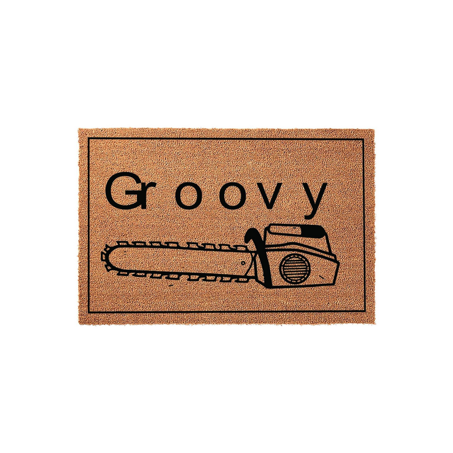 Groovy Chainsaw Coir Doormat featuring a natural brown fiber texture with a black border, displaying the word Groovy in bold lettering above a detailed black graphic illustration of a chainsaw for a unique outdoor home entrance.
