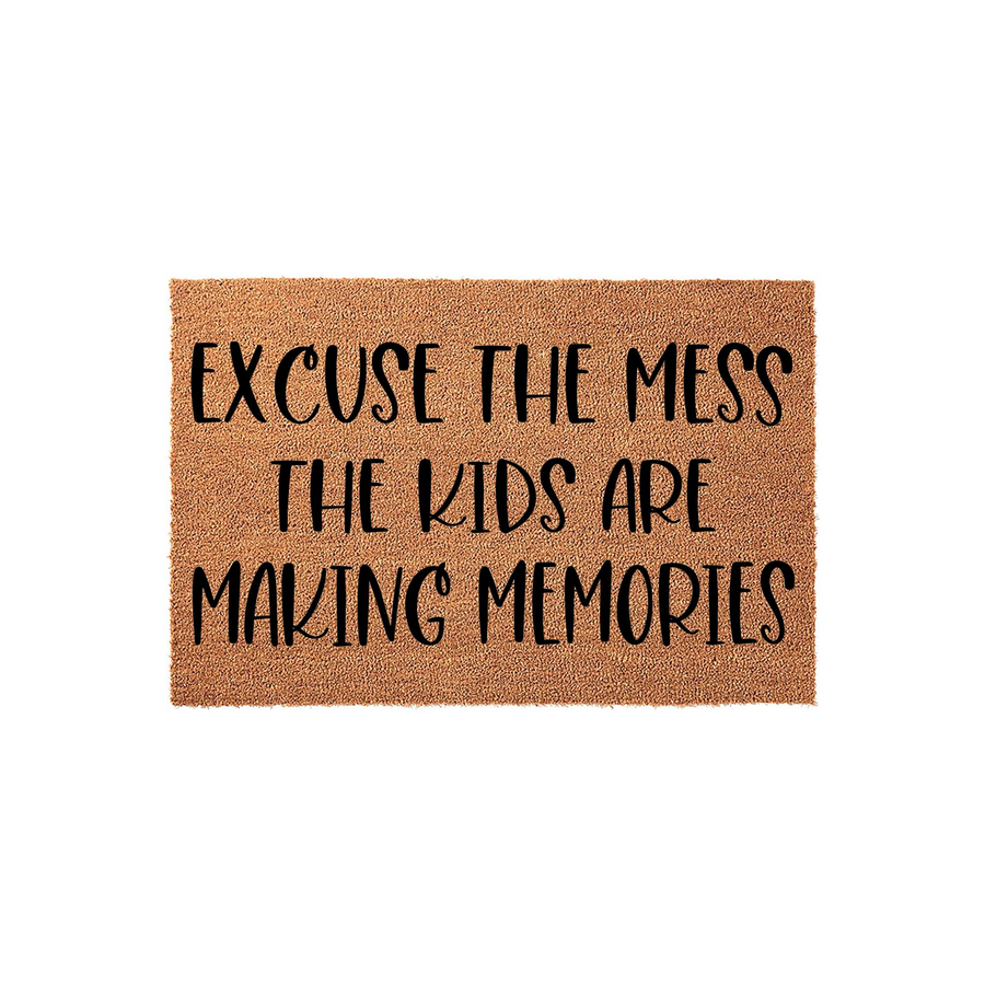 Excuse the Mess The Kids Are Making Memories coir doormat featuring natural brown fibers and bold black lettering, presented on a clean white background as a humorous and welcoming front porch decor piece for a busy family home.