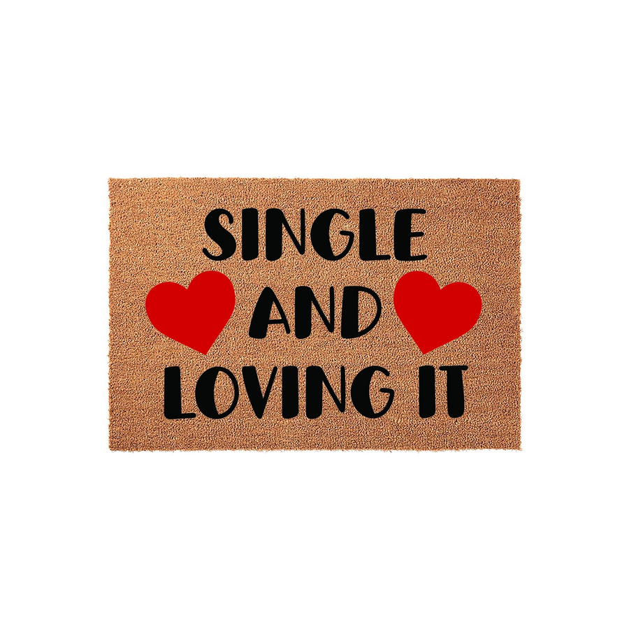 Single and Loving It coir doormat featuring bold black text and two bright red hearts on a natural tan fiber background, creating a fun and welcoming entrance decor piece for any apartment or home entryway that celebrates