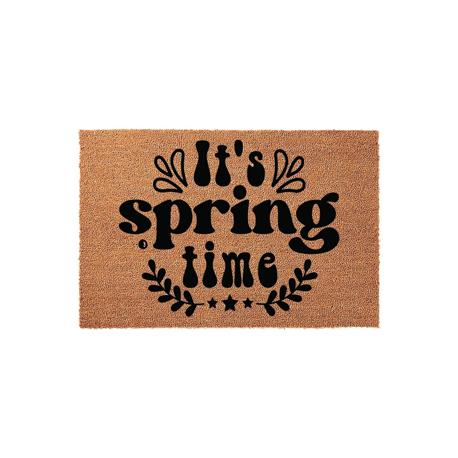 Springtime coir doormat featuring a natural tan fiber texture and bold black lettering that reads It's spring time, accented with decorative leaves and stars in a clean, modern design suitable for a front porch entryway.