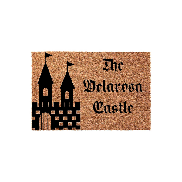 Personalized Castle Doormat featuring a natural coir texture with a black graphic of a fairy tale castle and the custom text The Velarosa Castle printed in a bold gothic font, creating a charming entryway accent for any home.