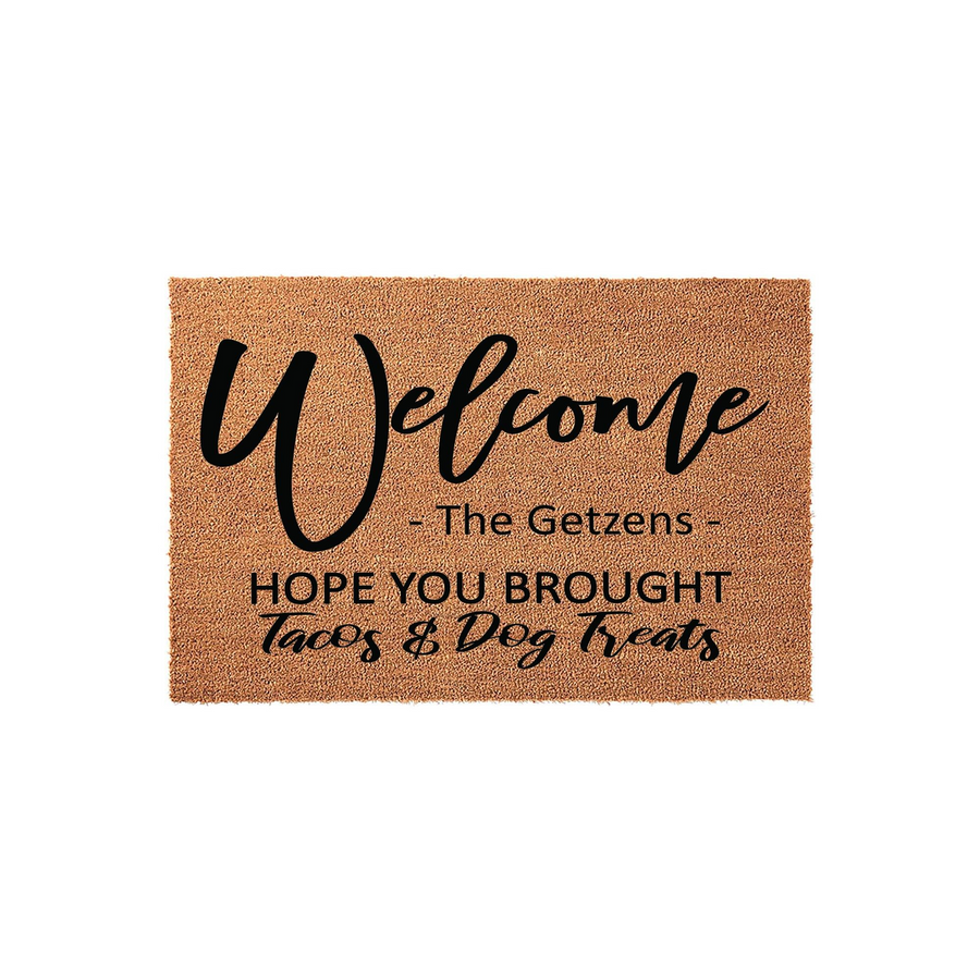 Personalized Welcome Doormat featuring a natural coir texture with black text that reads Welcome, a space for a family name, and the humorous phrase Hope You Brought Tacos and Dog Treats for a fun entryway decor addition to your