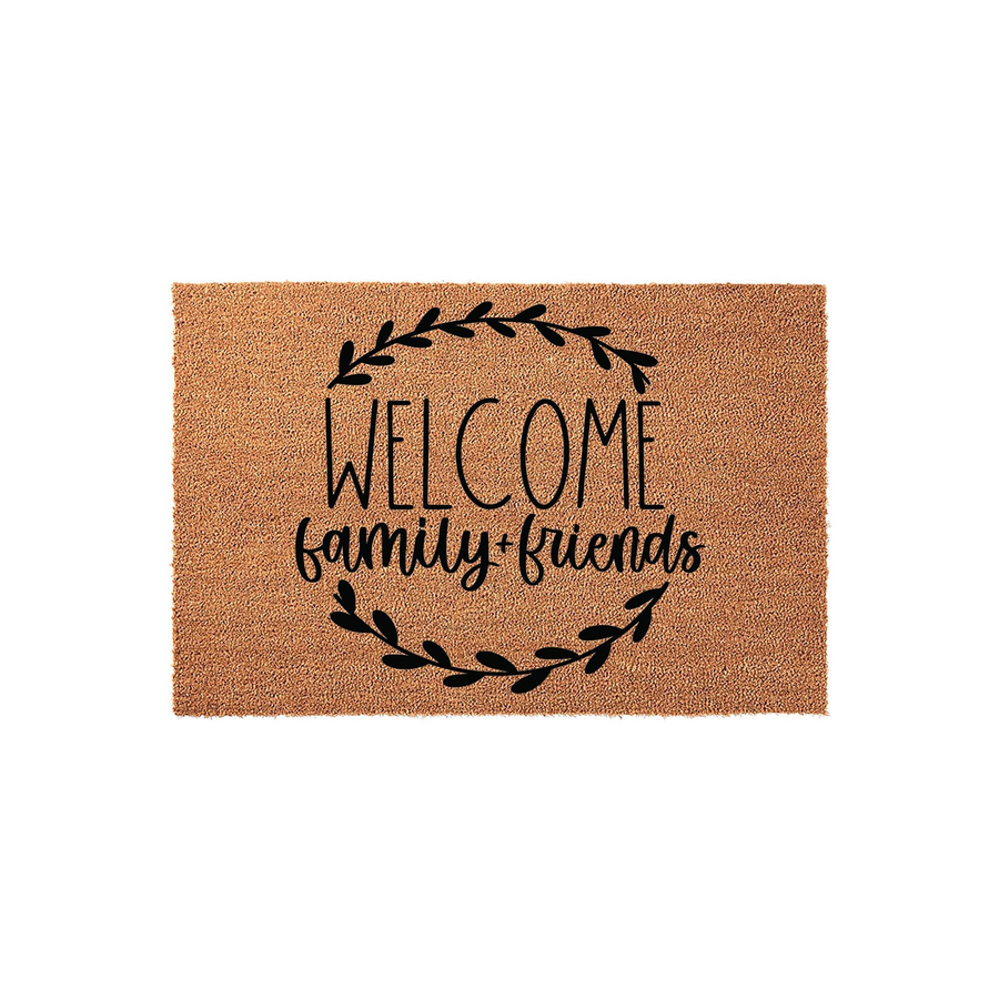 Welcome Family and Friends coir doormat featuring a natural brown fiber texture and black printed text centered inside a decorative leafy wreath design, creating a warm and inviting entryway accent for your home front porch decor.