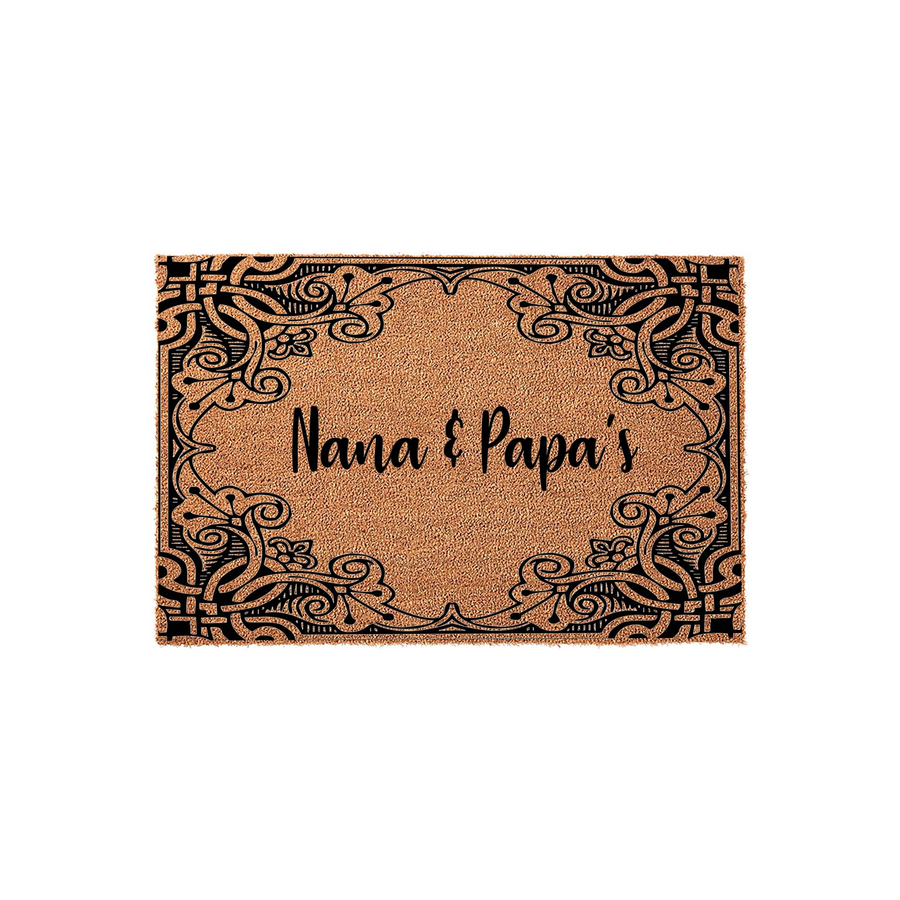 Nana and Papa's personalized coir doormat featuring a decorative black filigree border design on a natural tan fiber background, creating a welcoming entrance piece for a grandparent's home on a clean white studio backdrop.