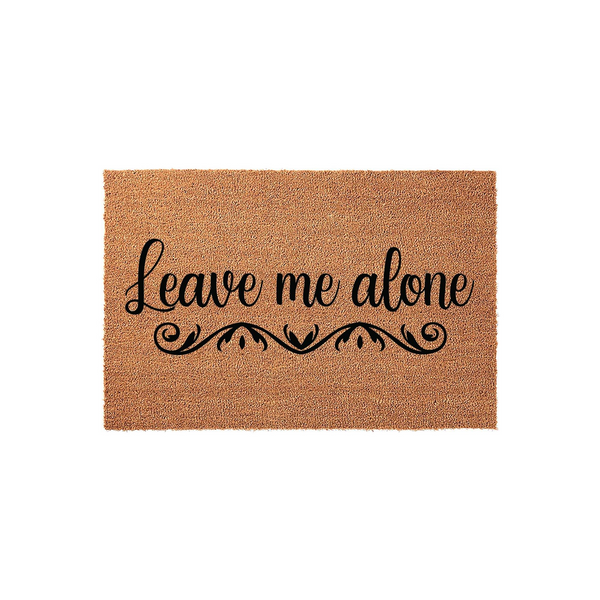 Leave Me Alone funny coir doormat featuring bold black cursive text and a decorative scroll flourish, set against a natural brown coconut fiber background for a humorous and welcoming touch to your front porch entryway decor.