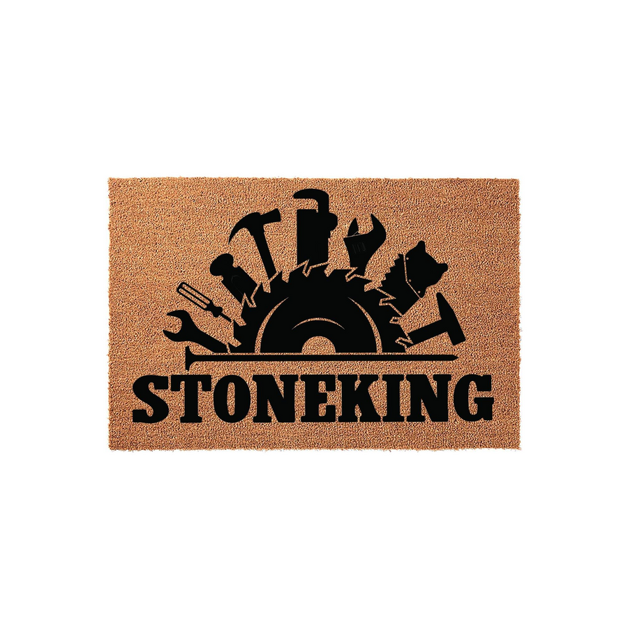 Personalized Handyman Coir Doormat featuring a black graphic of a circular saw blade surrounded by various construction tools like a hammer and wrench, with a custom family name printed in bold black lettering on a natural tan