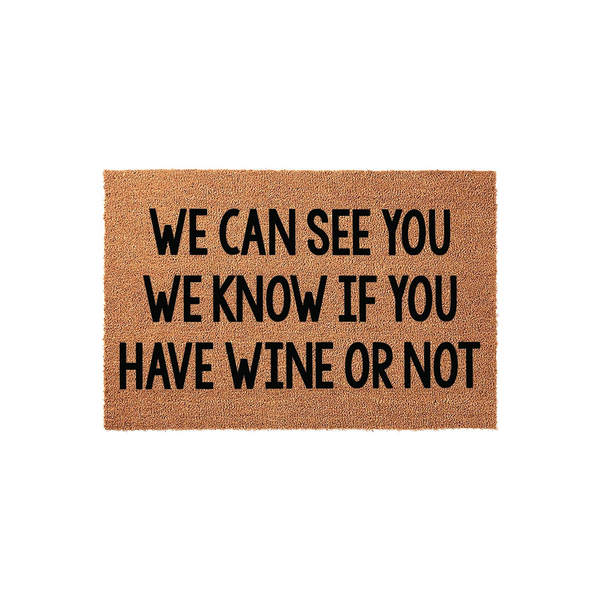 Funny Wine Lover Doormat featuring a natural coir texture and bold black text that reads We Can See You We Know If You Have Wine Or Not, making it a humorous front porch welcome mat for any home entrance or wine enthusiast