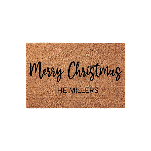 Personalized Merry Christmas coir doormat featuring a natural brown fiber texture with black script and block lettering, designed to display a custom family name for a festive holiday entryway decoration on a plain white