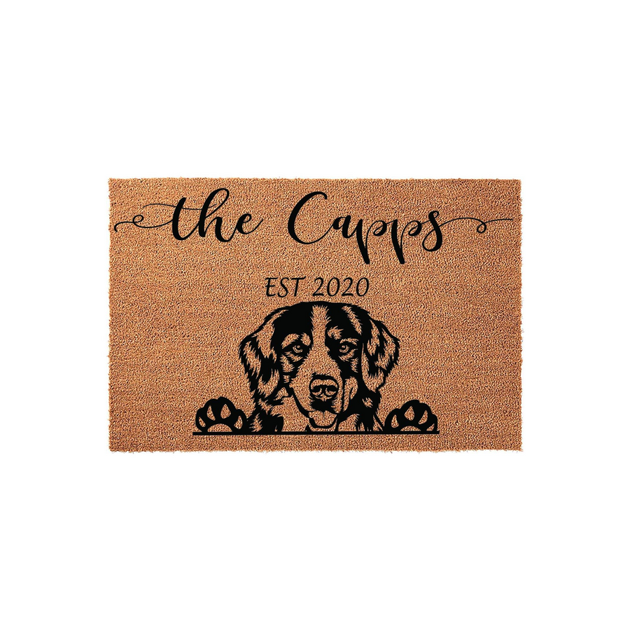 Personalized Bernese Mountain Dog doormat featuring a natural coir texture, custom family name text, and an established year, showcasing a charming illustration of a dog peeking over the bottom edge on a clean white background.