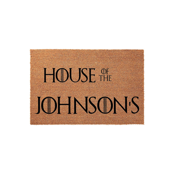 Personalized fantasy-themed coir doormat featuring bold black typography that reads House of the Johnson's, designed with a unique sword-inspired font style on a natural brown textured fiber background for a durable front porch