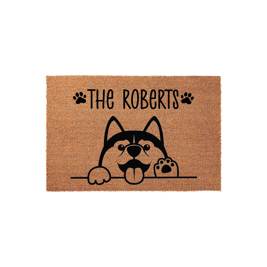 Personalized Husky dog doormat featuring a cute illustrated Siberian Husky peeking over a line with paw prints and space for a family name, set against a natural tan coir fiber background for a welcoming and durable front porch