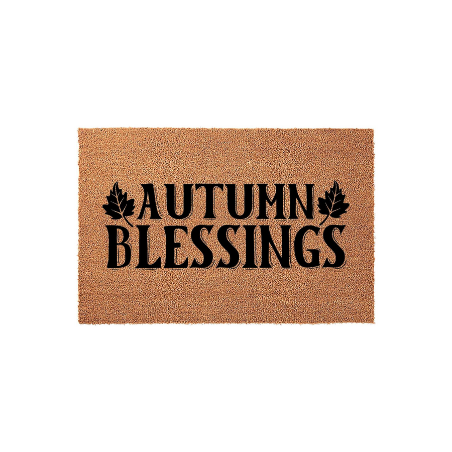 Autumn Blessings coir doormat featuring a natural tan fiber texture with bold black text and decorative leaf accents, providing a festive seasonal welcome for your front porch entryway during the fall harvest holiday season.